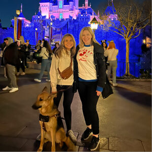 Lexie with her guide dog and friend at a theme park
