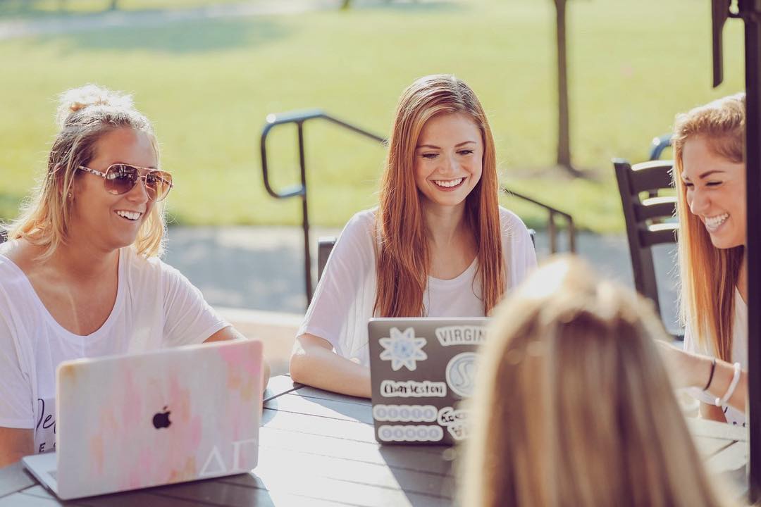Girls sitting around a table with their computers