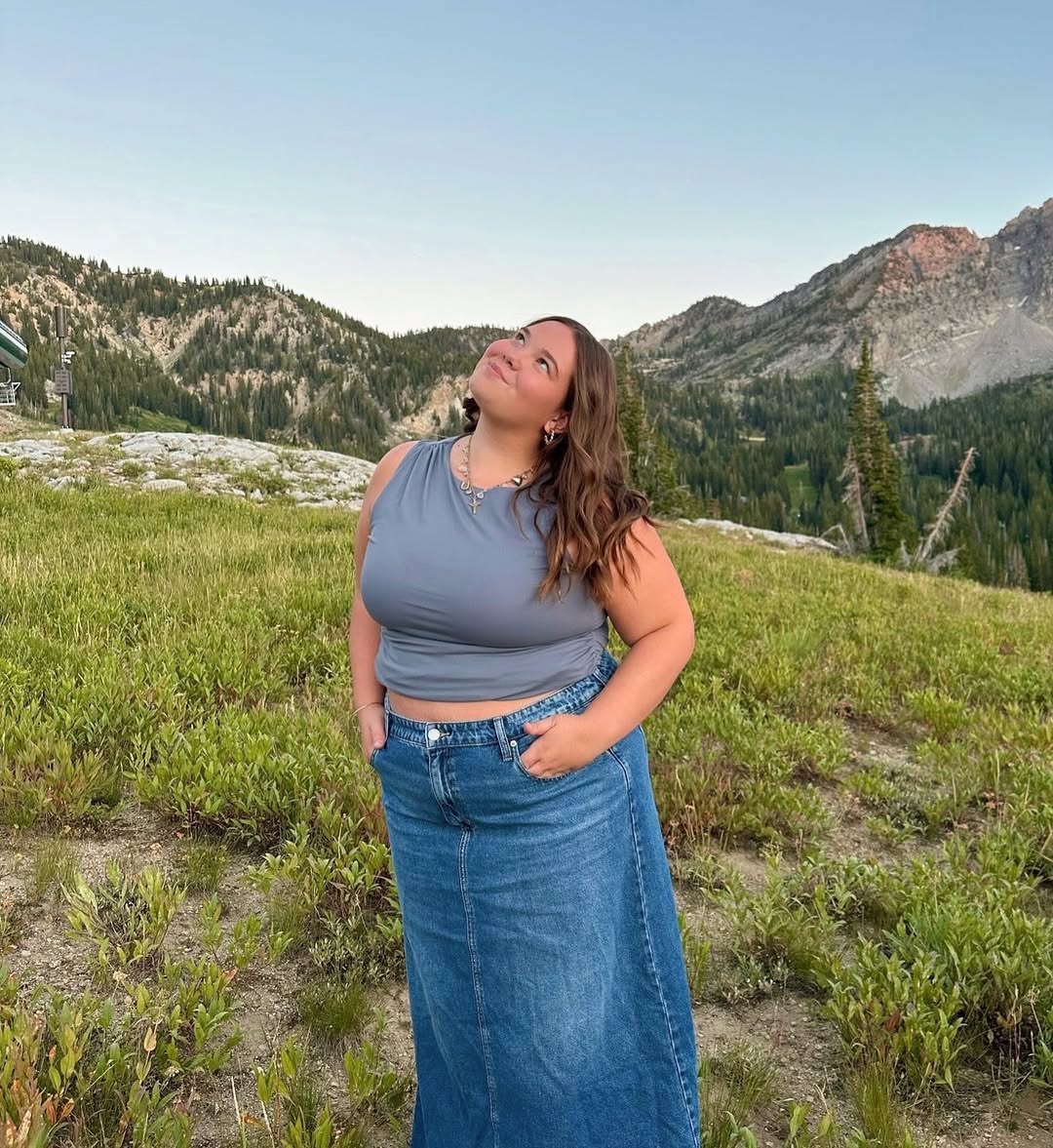 Kate posing for a photo in a outdoor setting with mountains