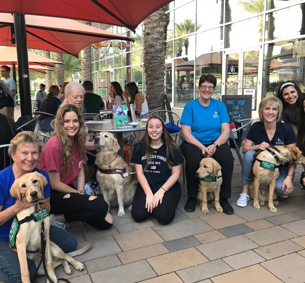 Alumnae members next to service dogs