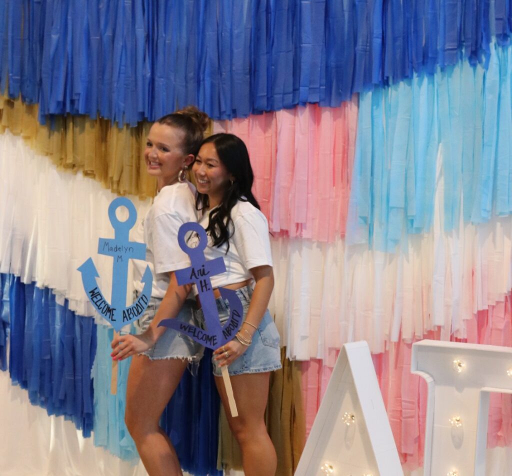 Girls taking photo with anchor sign