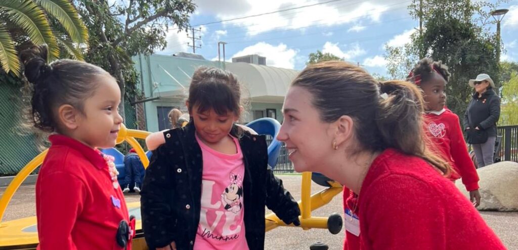 Girl talking to two little girls