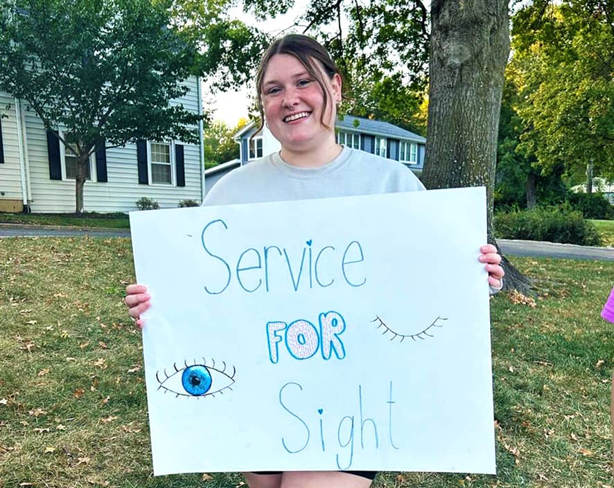 Girl holding sight sign saying Service for Sight