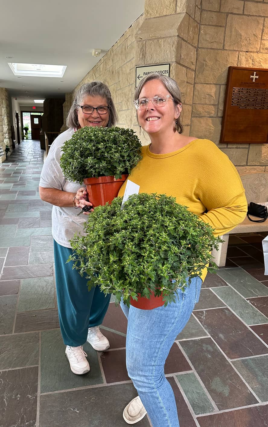 Two women holding plants