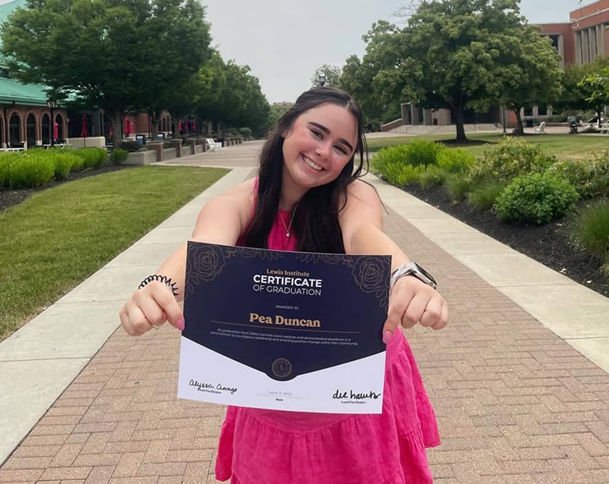 Girl holding up Lewis Institute certificate