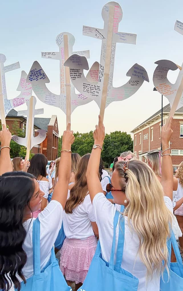 DG members holding up Delta Gamma anchor signs with words on them