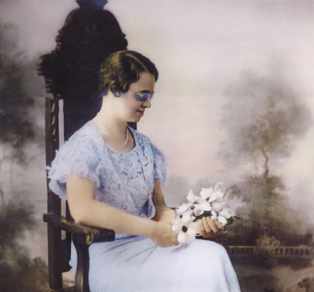 Vintage image of a blind woman sitting with flowers