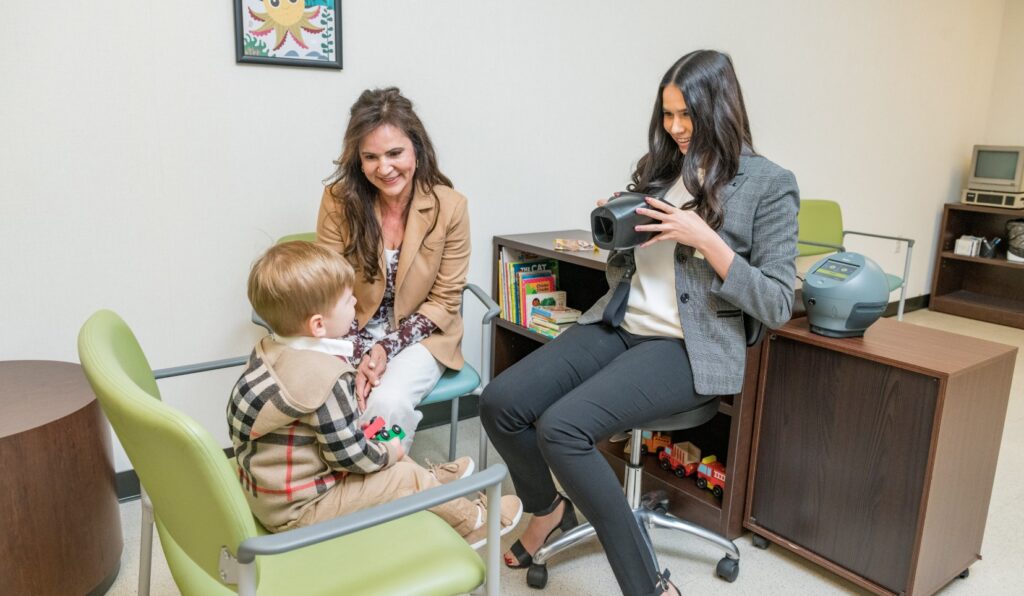 Woman holding up sight image at little boy