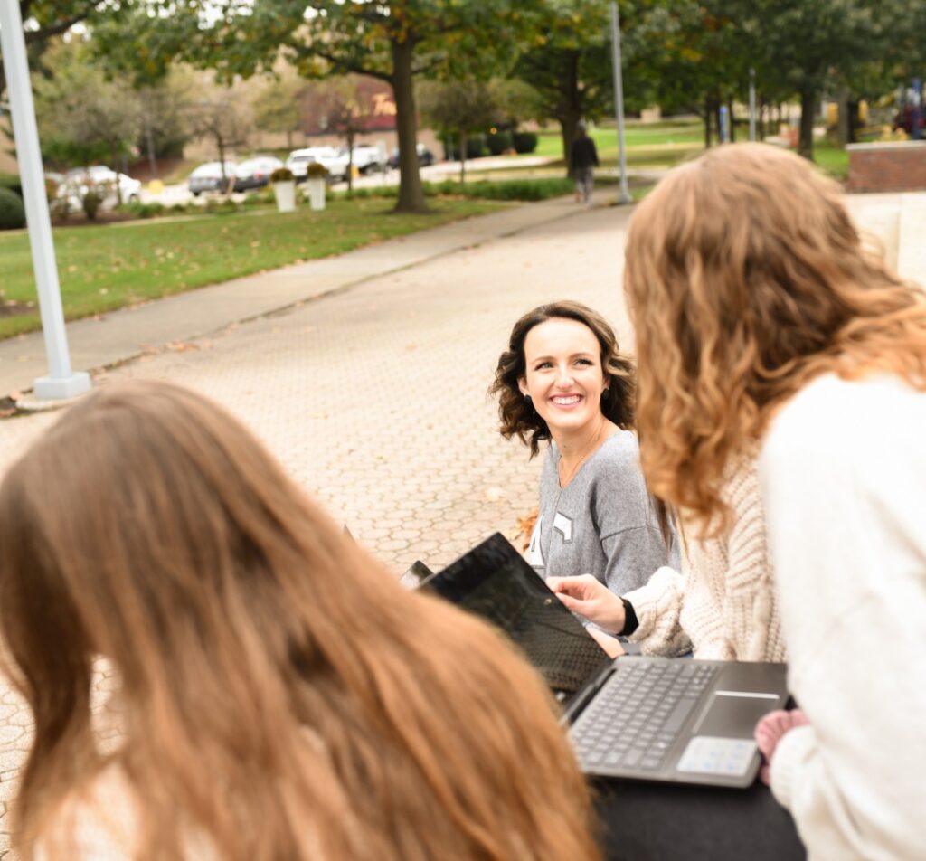 Girls working on computers outside