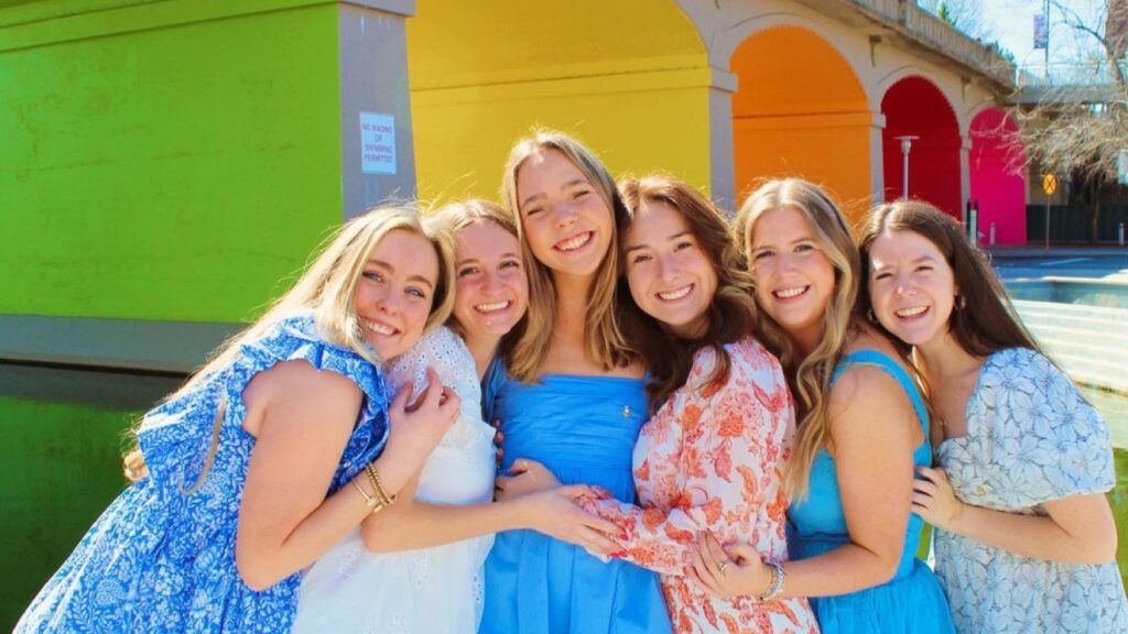 Girls hugging in front of colorful bridge
