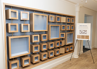 A wall of small and large wooden boxes that spin 360 degrees.