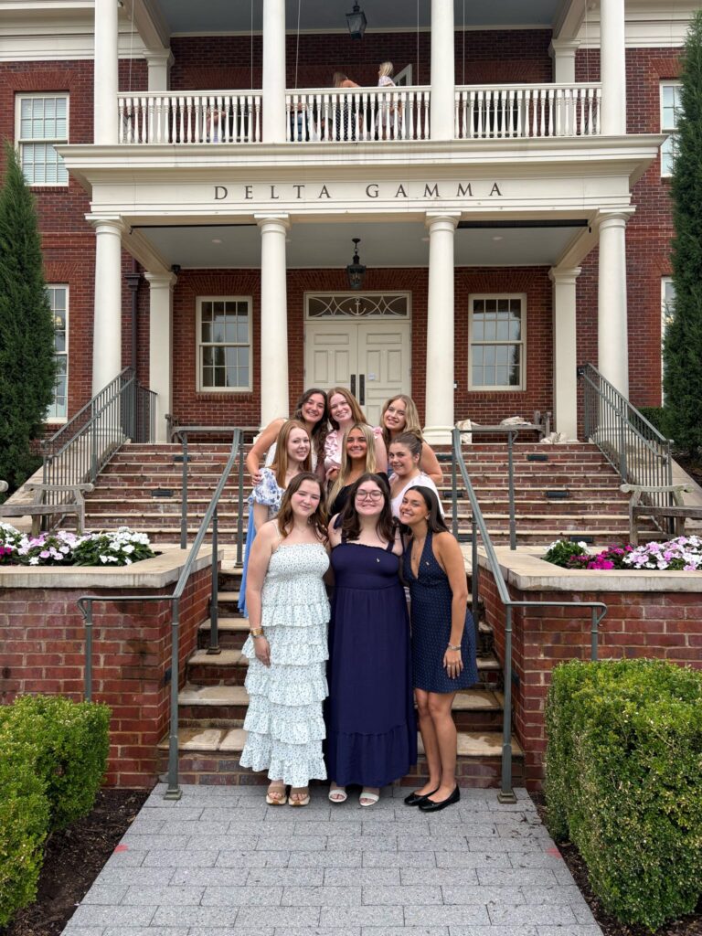 DG Women standing in front of a Delta Gamma house.